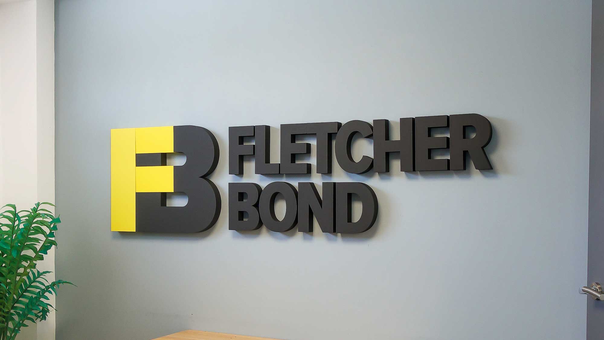 3D dimensional logo sign with raised letters mounted on an office wall