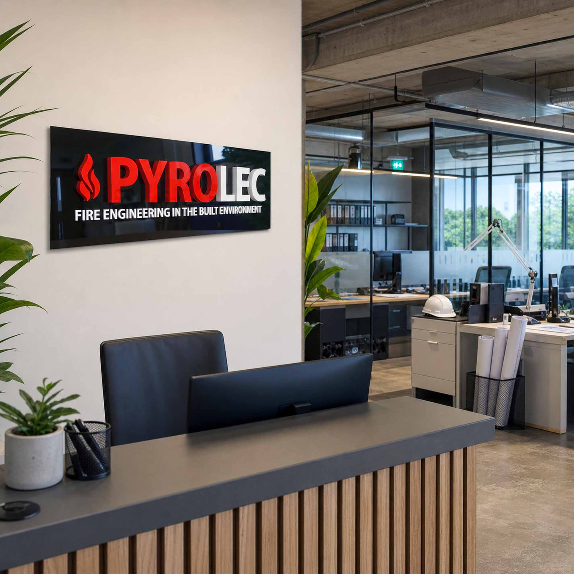 Pyrolect acrylic plaque displayed in a professional fire-engineering office reception and workspace.